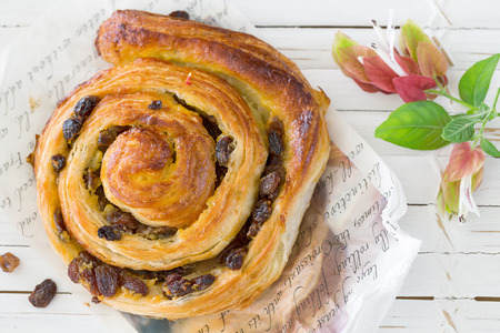 Raisin Danish pastry swirl, brioche, on white wooden trayの写真素材