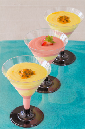 Passion fruit and strawberry mousse on blue plateの写真素材