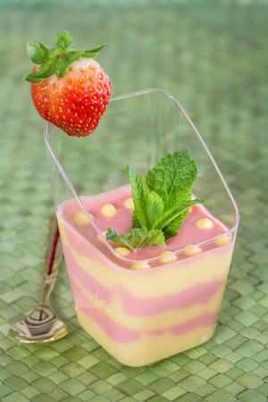Passion fruit and strawberry mousse  on green backgroundの写真素材