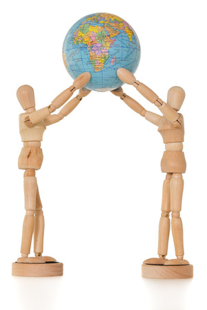 Two wooden dolls holding globe, isolated on white backgroundの写真素材