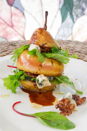 Vertical composition of pear salad with green leafs, blue cheese and walnutsの写真素材