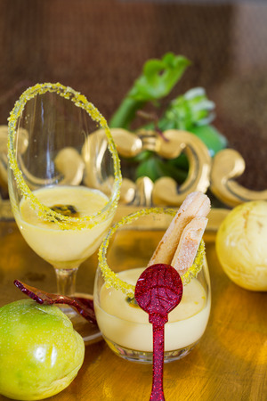 Two glasses of passion fruit dessert with red spoonの写真素材