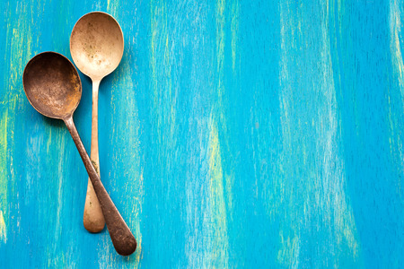 Two Old vintage spoons on blue wooden background top viewの写真素材