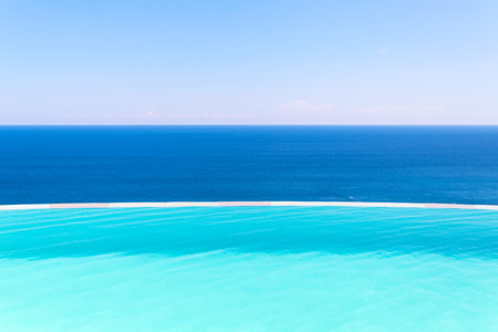 Swimming pool side on blue background of sea and sky の写真素材