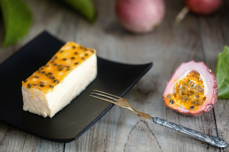 Passion fruits cheese cake slice  on dark plateの写真素材