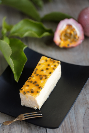 Passion fruits cheese cake slice  on wooden background. Vertical compositionの写真素材