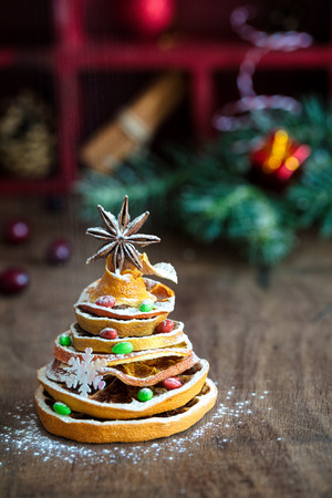 Christmas tree made out of dried orange slices and anise star, with festive decoration on background, vertical compositionの写真素材