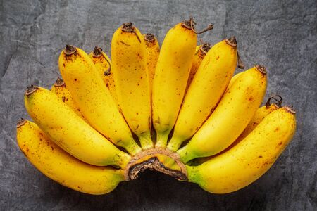 Bunch of fresh ripe yellow bananas on dark background, top viewの写真素材