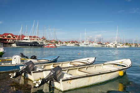Old vintage fishing boats in sunny summer day at marina of Eden Island, Mahe, Seychellesの写真素材
