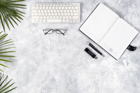 Flat lay office desktop work space of wireless keyboard, pen, and Glasses on gray background, top view, copy space の写真素材
