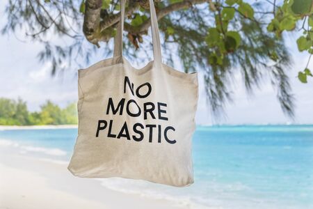 No More Plastic eco bag on  tree brunch with sandy tropical beach and blue sea backgroundの写真素材