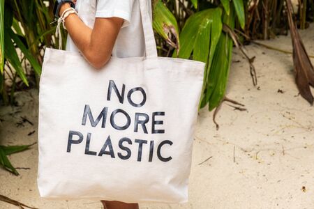 No More Plastic eco bag on shoulder of young girl on tropical island