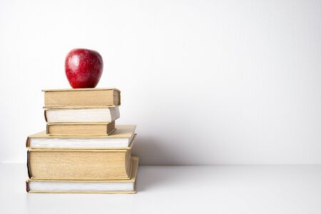 Books stuck with red apple with copy space, isolated on white backgroundの写真素材