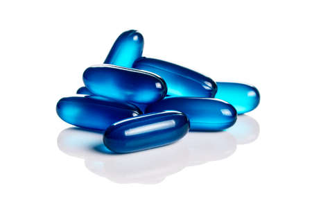 Close up of blue soft gel capsules isolated on the white backgroundの写真素材