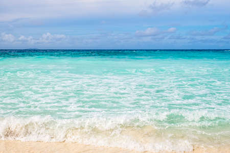 Crystal clear ocean water and shore  with blue sky background