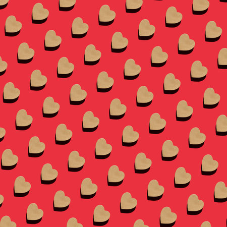 Seamless Pattern of craft gift box in the shape of heart on red background top view Flat lay. Creative composition for Valentine`s.の写真素材