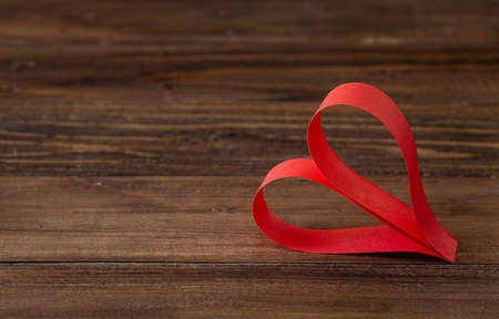 Single handmade red heart on brown wooden backgroundの写真素材