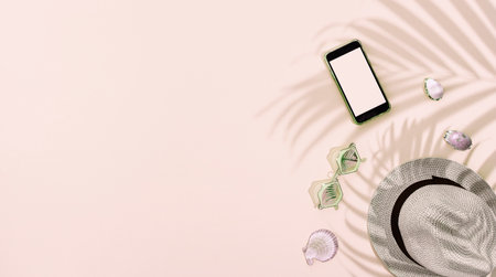Summer hat with personal accessories on pink background, with palm leafâs shaddowの写真素材