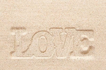 Word LOVE imprinted on sandの写真素材