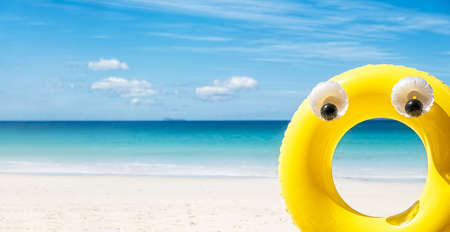 Large yellow rubber inflatable ring on sea side background at sunny day, tropical summer holiday...