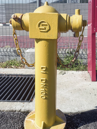 Penang, Malaysia â April 23, 2025: A bright yellow fire hydrant stands at the roadside, ensuring quick access for emergency services in case of fire.の写真素材