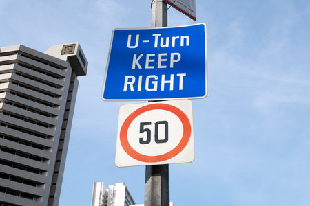 Singapore, Singapore - May 01, 2025: U-Turn sign and speed limit displayed against Orchard Road skylineの写真素材