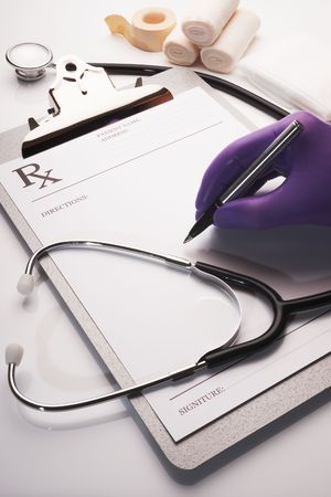 Surgeon writing rx prescription on clipboard with stethoscopeの写真素材