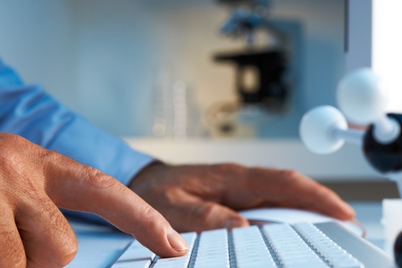 Scientist entering data into computer selective foucs の写真素材