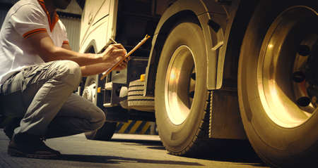Auto Mechanic is Checking the Truck's Safety Maintenance Checklist. Inspection Safety of Semi Truck Wheels Tires.の写真素材