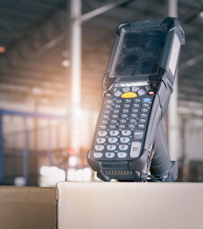 Barcode Scanner on Packaging Boxes in Storage Warehouse. Computer Mobile Work Tools for Inventory...