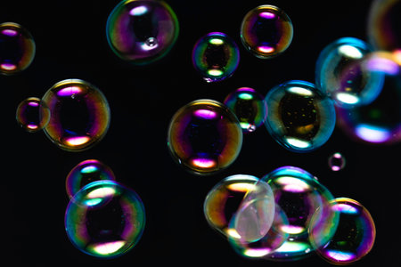Abstract Beautiful Colorful Transparent Soap Bubbles on Black Background. Rainbow Colors. Soap Suds...