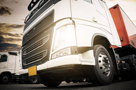 Semi Trailer Trucks on The Parking Lot with Turn on Headlights. Diesel Truck, Trucking, Container Cargo Shipping. Freight Truck Logistic, Cargo Transport.の写真素材