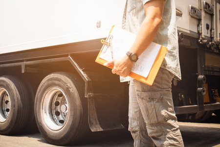 Truck Drivers Hold a Clipboard The Checking Container Door. Security of Cargo Shipping. Maintenance Check. Inspection Safety Checks Before Driving. Delivery Freight Truck Logisticsの写真素材