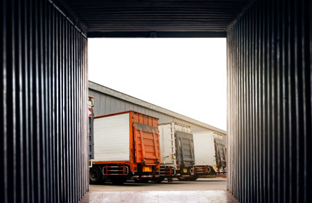 Container Trucks on The Parking Lot at Warehouse. Lifting Ramp Trucks. Commercial Shipping Truck Transport. Delivery Trucks. Distribution Warehouse. Freight Truck Logistics.の写真素材
