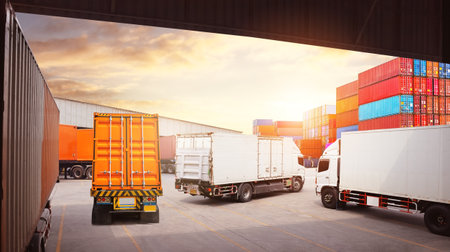 Container Trucks on The Parking Lot at Warehouse Port. Trucks Loading Dock Warehouse. Distribution...