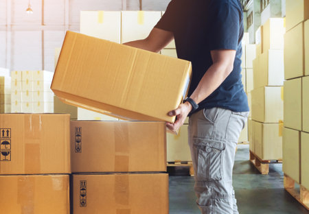 Warehouse Workers Lifting Package Boxes Stack on Pallets. Cartons, Cardboard Boxes. Supply Chain, Shipment Boxes, Supplies Warehouse Shipping. Logistics Warehouse.の写真素材