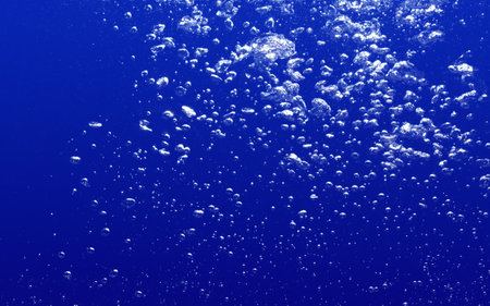 Motion of Air Bubbles Float Up Underwater. Pure Drinking Water, Oxygen Relaxation. Blue Water and Bubbles Textured Background.の写真素材