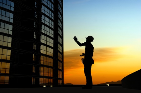 Silhouette of a worker on a background skyの写真素材