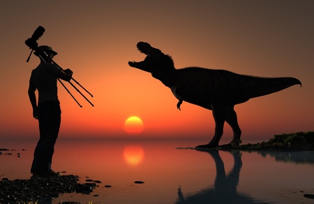 Silhouettes of photographer and dinosaur at sunset.の写真素材