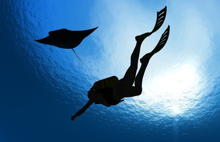 Girl with a diving under the water on a blue background.の写真素材