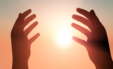 Silhouettes of hands in the sunshine.の写真素材