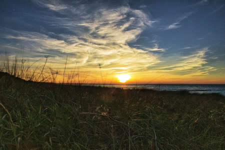 sunset on the beach of zingst on the baltic sea. with view of the sea and beautiful colors of the skyの写真素材