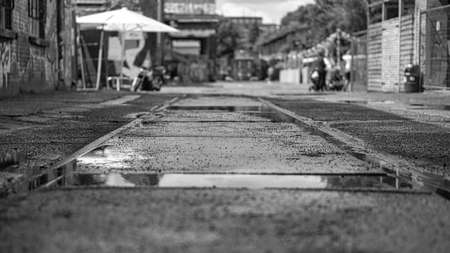 road tracks through the asphalt in a street in berlin depicted in black and white. texture and...