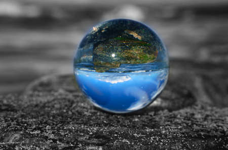 glass globe on the beach of the baltic sea. Black and white photo with a color glass ballの写真素材