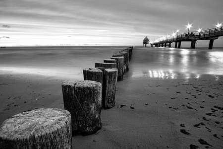 the pier in Zingst on the Baltic Sea, with a long exposure in black and white. a seaside attraction...
