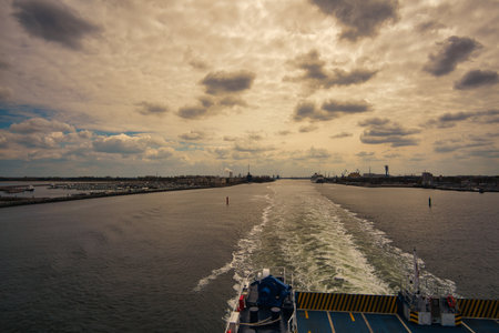 Rostock harbor exit. Looking back to WarnemÃ¼nde from the ship sailing to Sweden. Cloudy sky in spring. It goes on vacationの写真素材