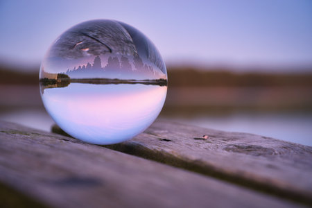 Glass ball on a wooden pier at a Swedish lake at evening hour. Nature shot from Scandinaviaの写真素材