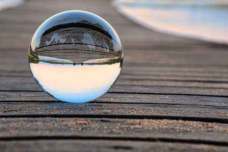Glass ball on a wooden pier at a Swedish lake at evening hour. Nature shot from Scandinaviaの写真素材