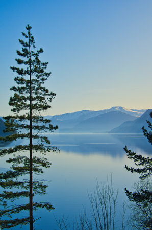 View of Oppstrynsvatnet lake in Norway in the morning hours. Snow-covered mountains in the background. Calm water in mountain lake. Landscape shot from Scandinavia.の写真素材