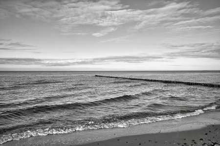 On the coast of the Baltic Sea in black and white. Waves roll onto the sandy beach. Nature photo by the seaの写真素材